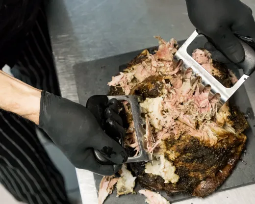 Fleisch wird mit Handschuhen gezupft